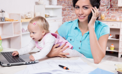 Frau mit Baby am PC